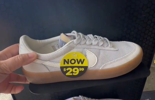 White sneaker with gum sole on display, yellow sale tag reads NOW .99.